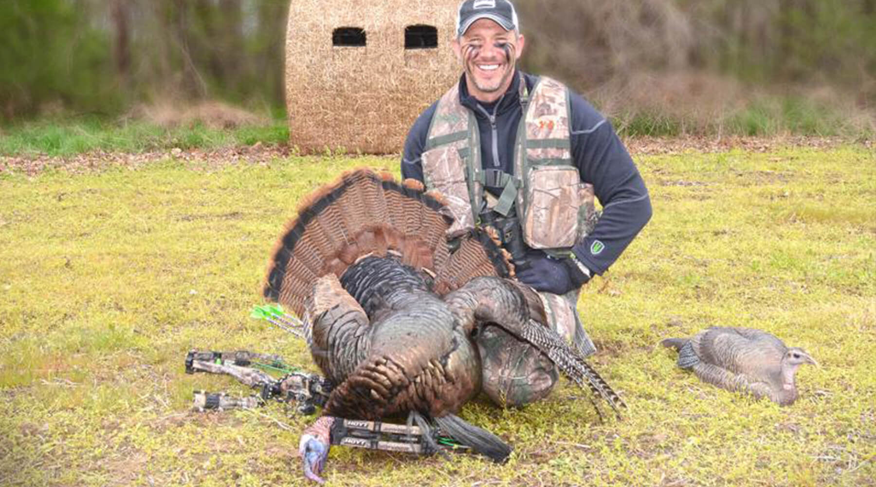 John Dudley with a turkey in front of a bale blind.