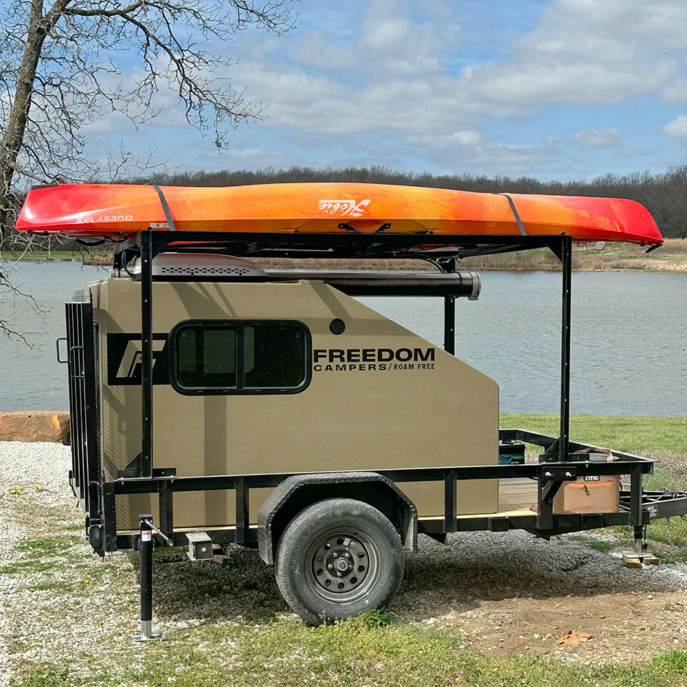 Tan Freedom Camper with kayak near river