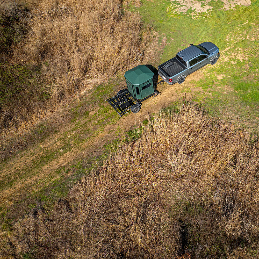 Truck towing a Hydraulic Trailer to a food plot.